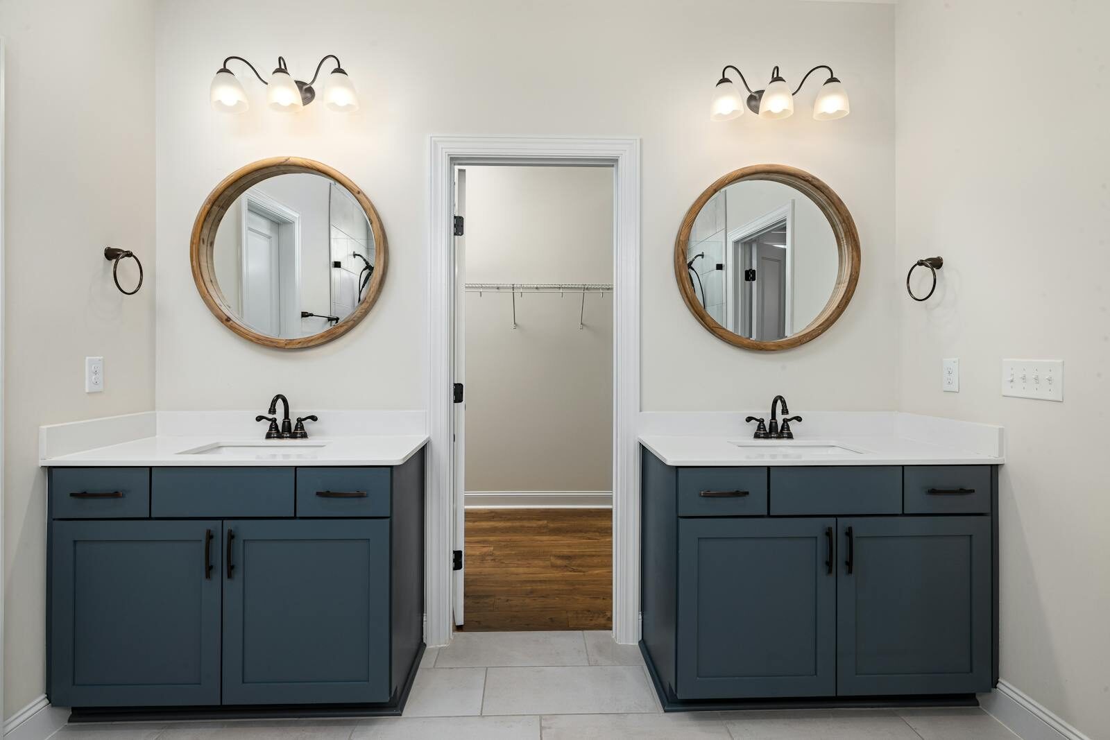 A beautifully designed modern bathroom with dual sinks, round mirrors, and stylish lighting.