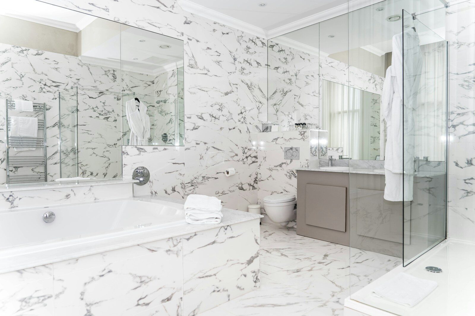 Luxurious marble bathroom with bathtub and vanity.