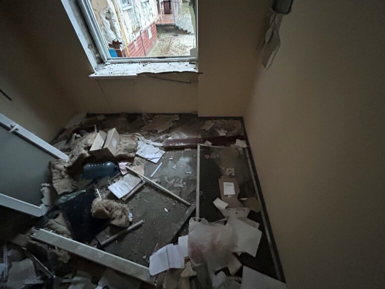 a run down room with a window and debris on the floor